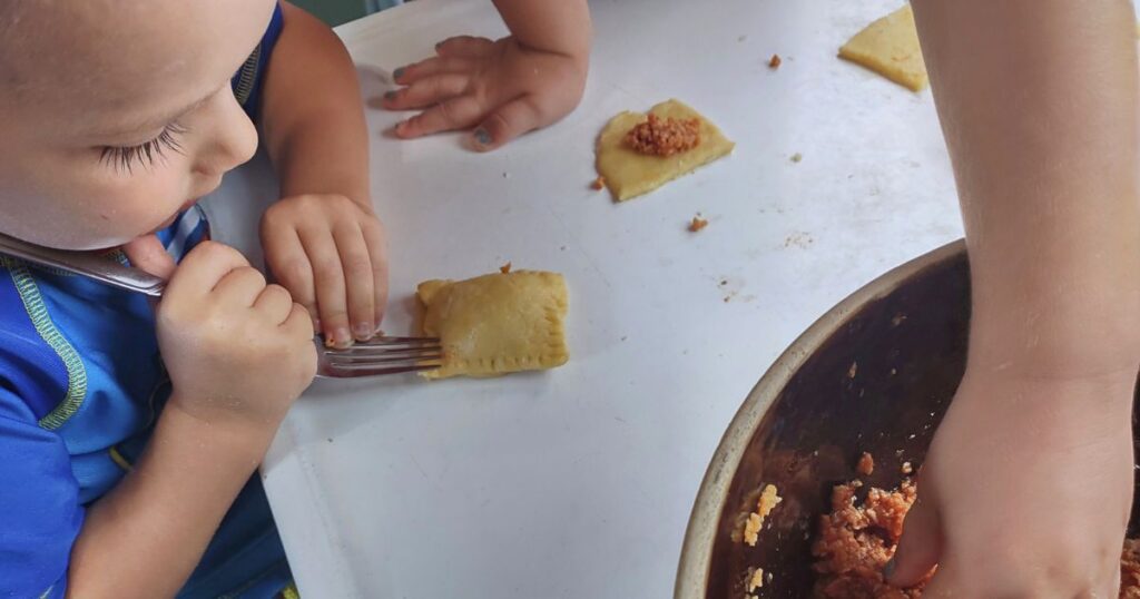 3-5 year old crimps the edges of the ravioli with a fork. Creative activities for 3-5 year old's, preschool cooking activities, preschool learning games.